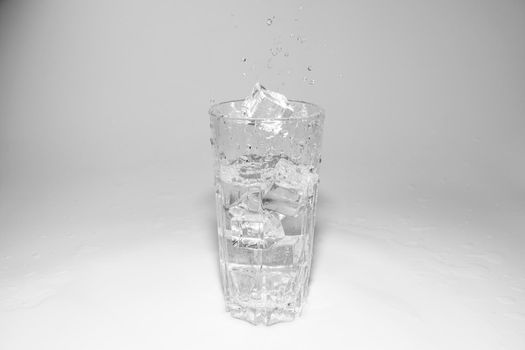 water splashes in a glass with ice on a white background. High quality photo
