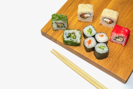 sushi and sticks on a wooden Board on a white background. High quality photo
