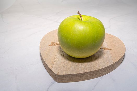 green Apple on the chalkboard in the shape of a heart . photo