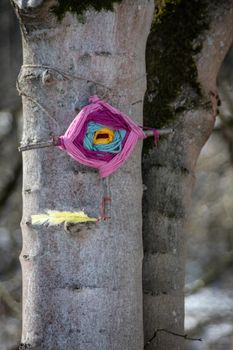 Magic protection symbol with feather hangs on tree