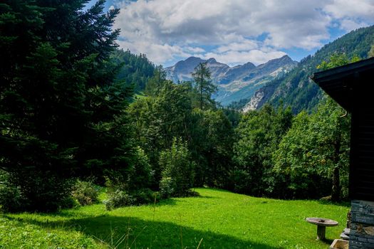 Mountain meadow in front of impressing alpine mountains spotted in Mogno, Ticino, Switzerland