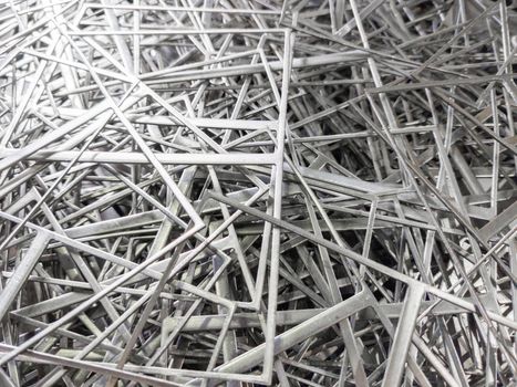 full frame abstract industrial background of stamping leftovers pile, close-up with selective focus.