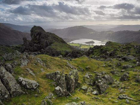 Helm Crag and the rock formation known as the 'The Lion and the Lamb' with Grasmere in the background and a glimpse of Windermere and Coniston Water on the horizon, Lake District, UK