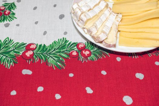 a plate of the sliced cheese on a New Year's tablecloth. High quality photo