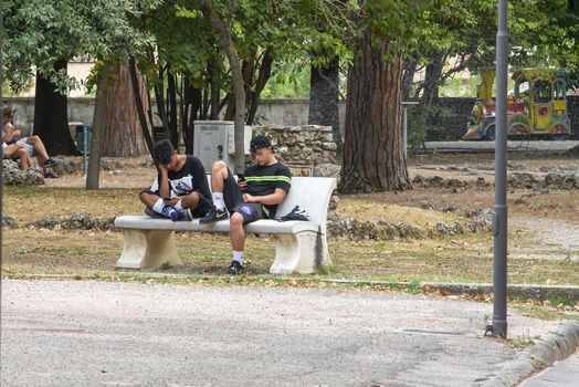 terni,italy august 16 2020:boys at the park with smartphones