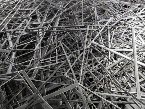 full frame abstract industrial background of stamping leftovers pile, close-up with selective focus.