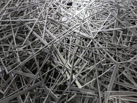 full frame abstract industrial background of stamping leftovers pile, close-up with selective focus.