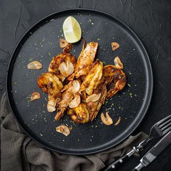Large grilled BBQ shrimp with sweet Mango sauce and curry set, on plate, on black background, top view flat lay