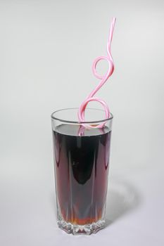 a glass of soft drink with a pipe on a light background. High quality photo