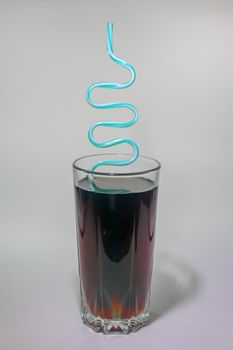 a glass of soft drink with a pipe on a light background. High quality photo