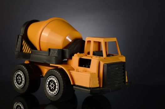 A toy cement mixer over a dark gradient background.