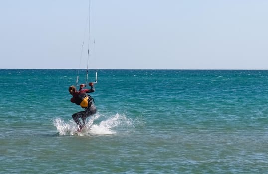 a kitesurfer surfing on the smooth azure water. recreational sport. A Man Rides A Kiteboarding In The Sea Water. extreme sport. High quality photo
