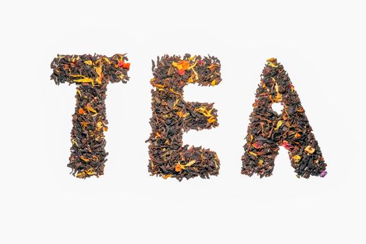 word black tea tea with fruit pieces and flower petals macro isolate. High quality photo