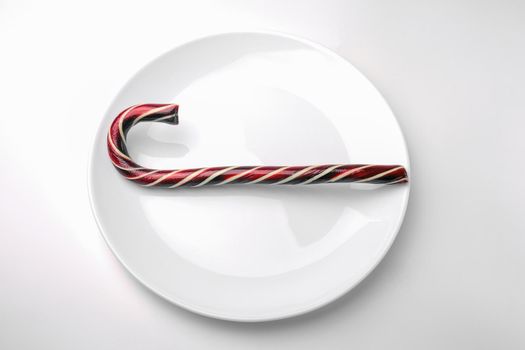caramel Christmas cane close up on a white background. High quality photo