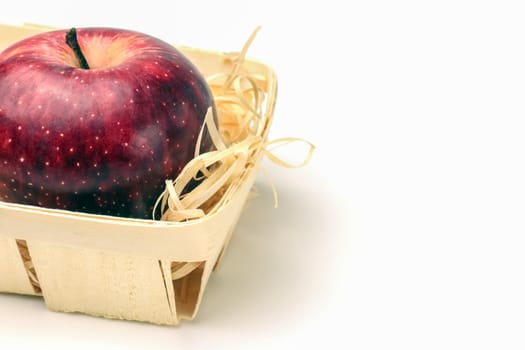 red Apple in a basket close-up on a white background. High quality photo