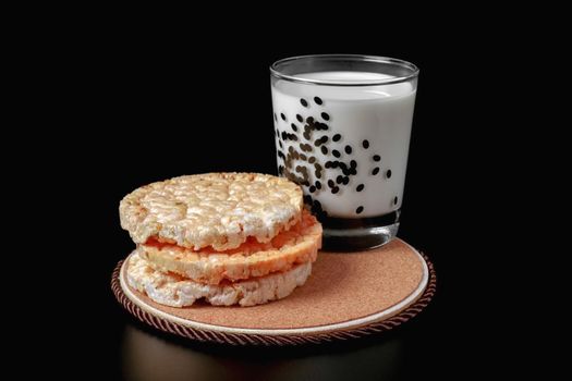 a glass of milk and cornbread on a black background. health food. isolate. High quality photo