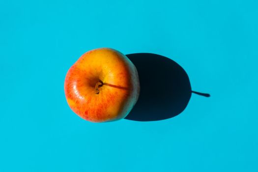 an Apple with a hard shadow on a plain background. the view from the top. blank for the pattern. High quality photo