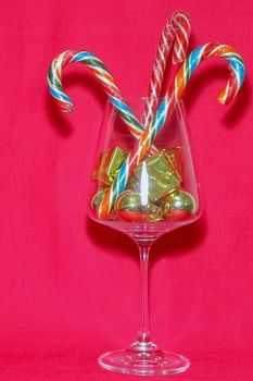 wine glass with Christmas decorations on a red background. high-quality photos