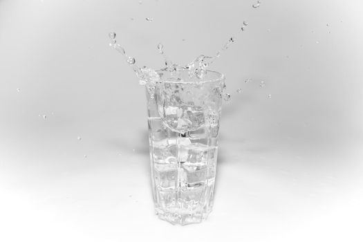 water splashes in a glass with ice on a white background. High quality photo