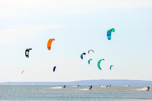 a kitesurfer surfing on the smooth azure water. recreational sport. A Man Rides A Kiteboarding In The Sea Water. extreme sport. High quality photo