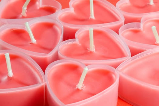 pink candles in the form of a heart on a red background for Valentine's day . High quality photo