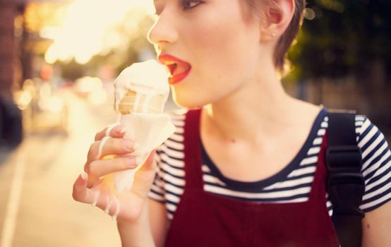 pretty woman with short hair eating ice cream outdoors leisure walk. High quality photo