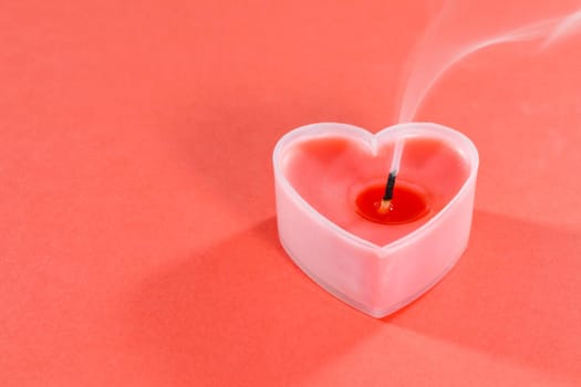 pink candles in the form of a heart on a red background for Valentine's day . High quality photo