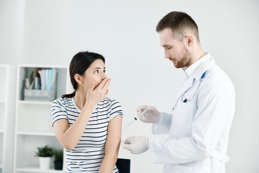 the patient covers her face with her hand fear of injections vaccination. High quality photo