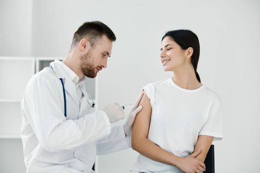 the doctor gives an injection of coronavirus infection into the patient's shoulder. High quality photo