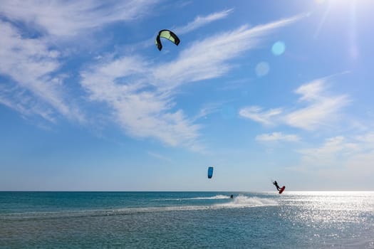 a kitesurfer surfing on the smooth azure water. recreational sport. A Man Rides A Kiteboarding In The Sea Water. extreme sport. High quality photo