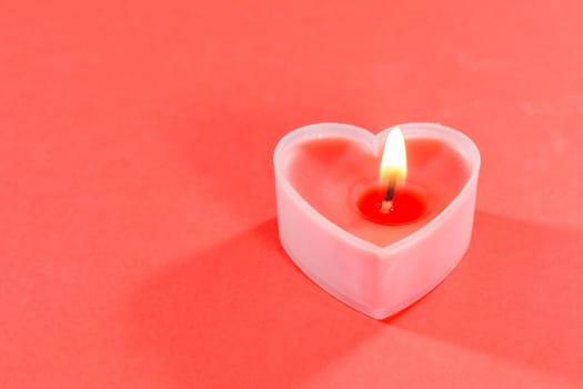 pink candles in the form of a heart on a red background for Valentine's day . High quality photo