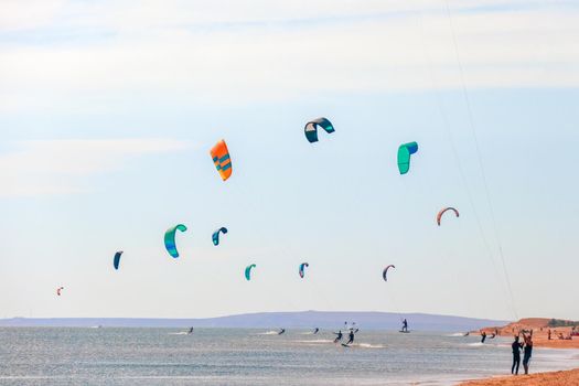 a kitesurfer surfing on the smooth azure water. recreational sport. A Man Rides A Kiteboarding In The Sea Water. extreme sport. High quality photo