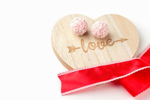 pink chocolates on a Board with a red ribbon. isolate on a white background. High quality photo