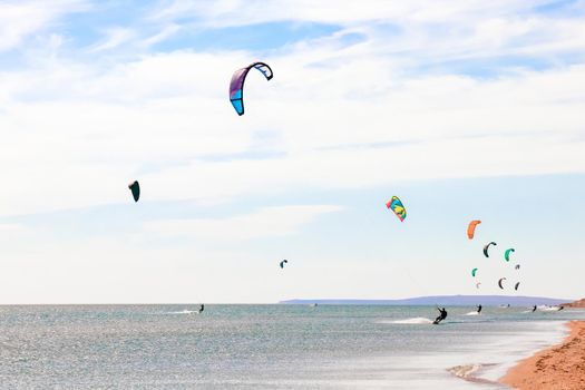 a kitesurfer surfing on the smooth azure water. recreational sport. A Man Rides A Kiteboarding In The Sea Water. extreme sport. High quality photo