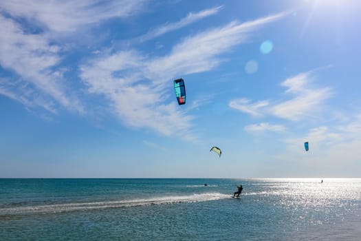 a kitesurfer surfing on the smooth azure water. recreational sport. A Man Rides A Kiteboarding In The Sea Water. extreme sport. High quality photo