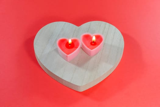 pink candles in the form of a heart on a red background for Valentine's day . High quality photo