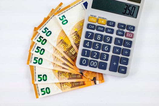 50 euro banknotes fanned with calculator on white background