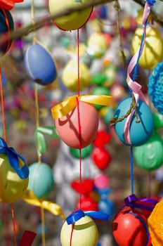 Traditional festive Easter tree. Pretty decorated colored Easter eggs with modern patterns hanging on a tree branch. Stock photo