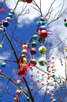 Many colorful easter eggs on the tree. A lot of Easter eggs decorated on tree. Traditional festive Easter tree. Pretty decorated colored Easter eggs with modern patterns hanging on a tree branch. Stock photo