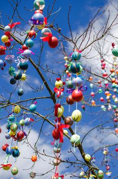 Traditional festive Easter tree. Pretty decorated colored Easter eggs with modern patterns hanging on a tree branch. Stock photo