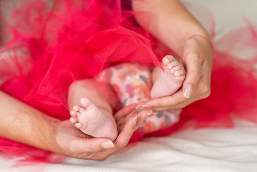 Mother holding tiny foot of newborn baby