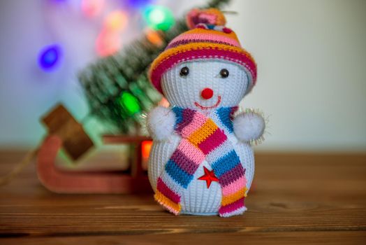 Snowman figurine.Blurry Christmas lights out of focus in the background. Bokeh