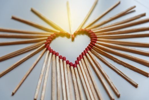 closeup of matchsticks arranged to form a heart shape with depth of field
