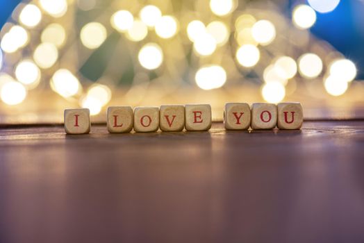 I LOVE YOU on wooden table background with lights.