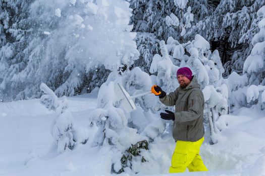 man clears snow from the mountains in december