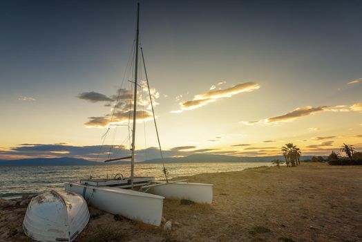 Sailboat on the beach at sunset in Greece