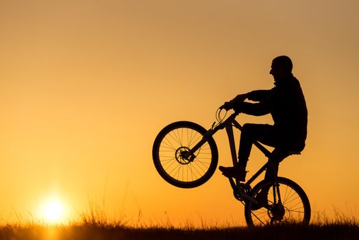 Silhouette of cycling on sunset background at sunset
