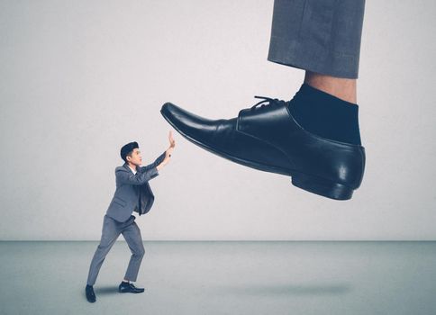 foot of leader or boss with authority huge trample on frightened employee with bullying, businessman in suite strong and defense, exploitation and dominance, scared and fight, business concept.