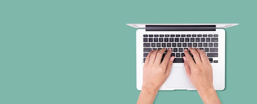 Businessman using laptop computer isolated on green background, business man typing keyboard on notebook with copyspace from above, network and communication online, top view, banner of website. 