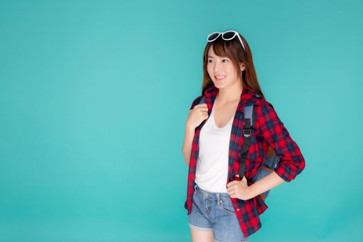 Beautiful portrait young asian woman wear sunglasses on head smile expression confident enjoy summer holiday isolated blue background, model girl fashion having backpack, travel concept.